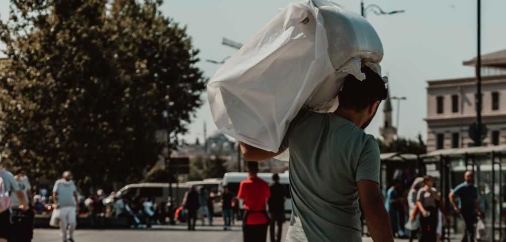 A man carries his luggage on his shoulder