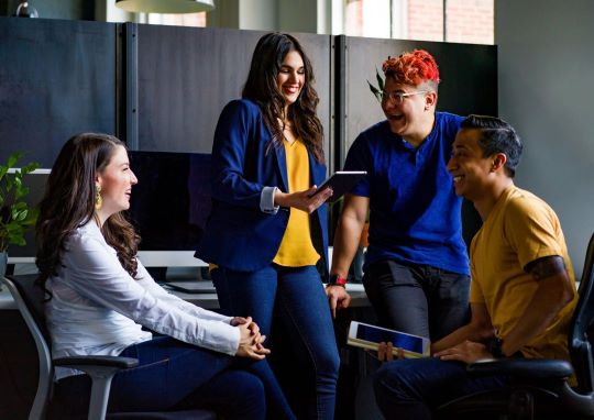 Four persons are talking happily with each other